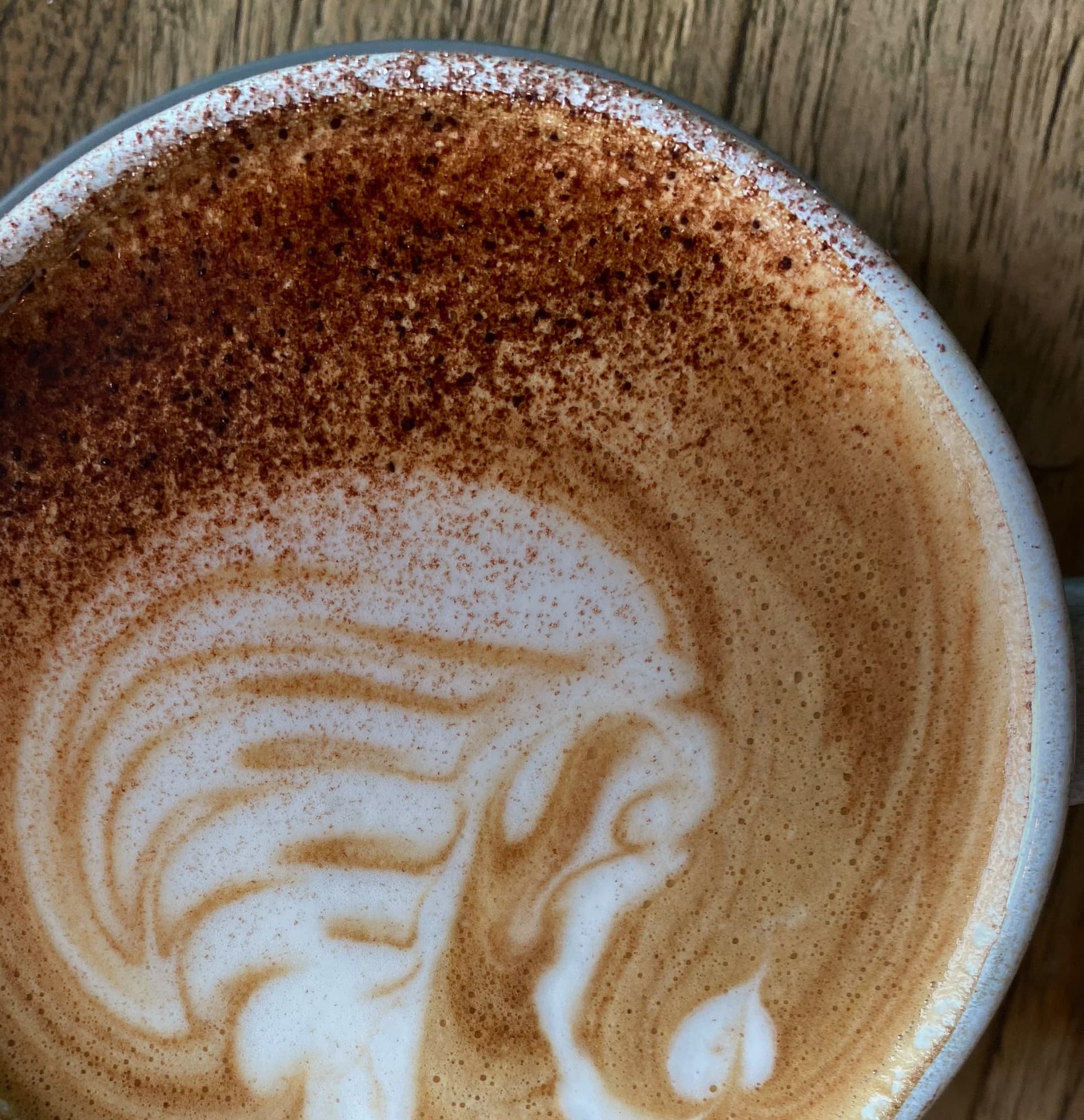 A cappuccino with latte art, dusted with chocolate